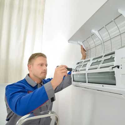 CoolAirBoss technician working on AC unit